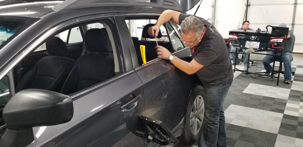 Paintless dent repair being performed on a vehicle panel